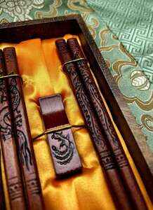 Dřevěné jídelní hůlky, mahagonově lakované s motivem draka ve tmavé dárkové krabičce 